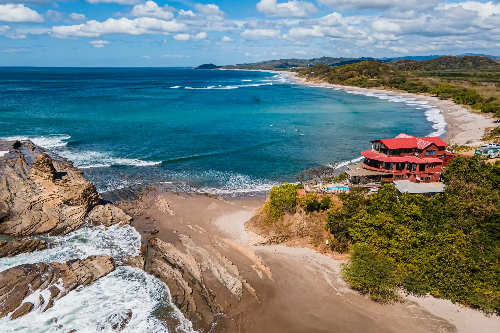Aerial view of Magnific Rock with turquoise ocean, sandy beach, rocky shoreline