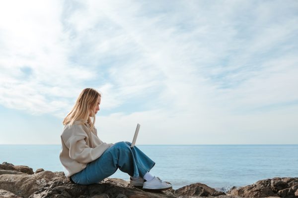 Remote work.Girl freelancer works remotely on the sea shore. workation, remote work,WFVH,Van Life vi Remote work.Girl freelancer works remotely on the sea shore. workation, remote work,WFVH,Van Life vi